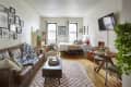 Cozy studio apartment with leather sofa and checkerboard rug.