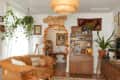 white living room with camel leather sofa, lots of warm colors and wood, vintage decor, and arched doorway decorated with fall leaves