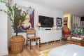Living room TV area with white cabinets and artwork