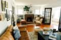 White bohemian living room with brick fireplace and tan leather sofa