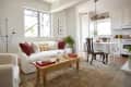 Living room with large tan carpet white couch and dining-room table