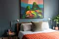 Large painting above neatly made bed.