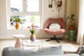 Circular accent tables in living room with pink chair.