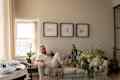 Two men smiling on white couch with framed art on white wall