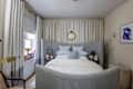 Bed with grey bed frame in front of white curtains