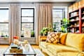 Ceiling to floor curtains in eclectic, plant filled living room.