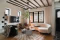 White living room with black accent and large circled fabric couch opposite to a black chair.