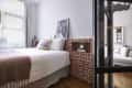 Brick walls in bedroom with neatly made bed.