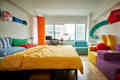 A bedroom with colorful furniture and wall art.