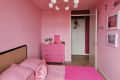 pink bedroom with pink bed, gallery wall, and pink dresser