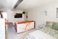 White studio apartment with bedroom and living room with TV visible