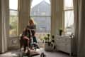 Couple posing in front of large bay window.