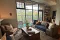 Living room with large couches facing each other and industrial floor to ceiling windows leading to patio