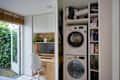 Closet opened showing stacked laundry machines.