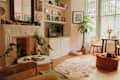 A TV below a bookshelf across from a fluffy rug.