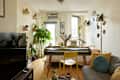 Main living area of studio apartment with colorful lamp and round mirror above couch.