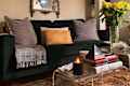 Dark couch and gilded mirror on white wall
