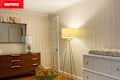 Nursery with wooden dresser, mirror, floor lamp, changing table, and toy rocking horse.