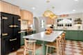 Checkered floor kitchen with green island and black appliances