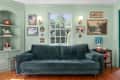 Mint green TV room with green velvet couch and dark wood furniture