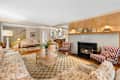 Living room with floral and striped upholstered furniture and checkered area rug