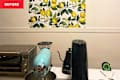 Kitchen countertop with a turquoise stand mixer, black kettle, and a floral lemon wallpaper above.