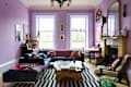 Two toned purple painted walls and trim in colorful living room.