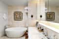 Modern bathroom featuring a freestanding white tub, large mirror, and decorative artwork.