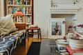 Cozy living room with a patterned sofa, bookshelves, a framed photo, and a coffee table with decor items.