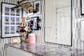 A stylish workspace featuring a marble countertop, jewelry organizer, framed art, and decorative wall elements.