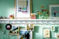 Framed images hang from shelf knobs.
