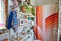 Shower curtain in plant filled bathroom.