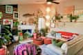 Capiz shell light hung in corner of eclectic plant filled living room