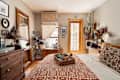 Cozy bedroom featuring a wooden dresser, telescope by the window, and decorative pillows on a bed with a patterned throw.
