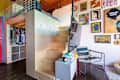 Stairs leading to a loft area with a closet, colorful wall art, a TV, and modern furniture in a cozy living space.