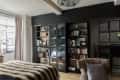 A bedroom with black shelving units in front of a black wall.