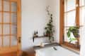 A bathroom with a clawfoot tub and a large window