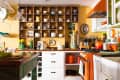 Colorful kitchen with open shelving displaying dishes, orange appliances, and a wooden island with grapes.