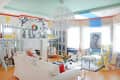 Eclectic living room with colorful art, white sofa, floral centerpiece, and unique decor elements like a zebra-patterned wall.