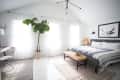 Bright bedroom with a large bed, woven bench, potted plant, and bull artwork on the wall.