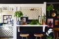 Kitchen with polka dot cabinets, plants, bar stools, and wall art, including a "Fresh Baked Pies" sign.