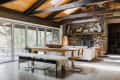 Rustic dining room with wooden table, fur-covered bench, stone fireplace, and large windows overlooking a patio.