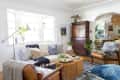 A cozy living room with lots of pillows, throw blankets, and a large wooden chest