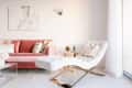 Pink velvet sofa with decorative pillows, white chaise lounge, abstract wall art, and a gold side table in a bright living room.