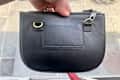 Person holding bag showing anti-theft travel clip.