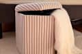 Blanket in striped IKEA storage pouf.