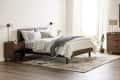 Modern bedroom with wooden bed, white bedding, nightstands, and a potted plant by a window with sheer curtains.