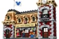 LEGO Disney Train Station set with Minnie, Chip, Dale, and Goofy figures, featuring a clock tower and Disney flags.