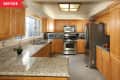 Spacious kitchen with oak cabinets, granite countertops, stainless steel appliances, and a large window.