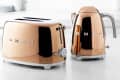 Copper Smeg toaster and kettle set on a kitchen countertop.